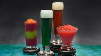 Dos bebidas congeladas cubiertas con bolitas de tapioca y dos cervezas servidas en vasos Pilsner