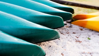 5 blue canoes and 2 yellow ones beached on pristine sand