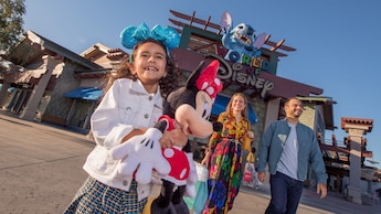Una familia de 3 personas delante de World of Disney en Disney Springs