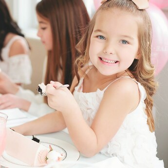 Cuatro niñas pequeñas sentadas a una mesa disfrutan un sabroso dulce