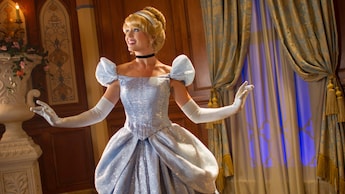 Cinderella junto a una gran ventana decorada con cortinas
