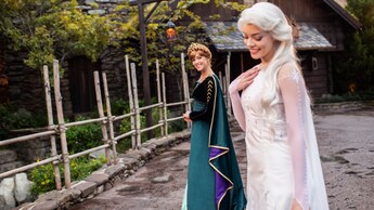 Anna smiles at Elsa as they stand in the Norway Pavilion in EPCOT