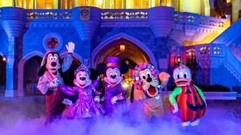 Goofy, Minnie Mouse, Mickey Mouse, Pluto y Donald Duck lucen sus disfraces de Halloween cerca del Cinderella Castle