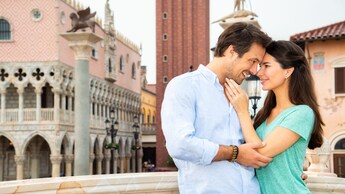 Una pareja sonriente se abraza y se mira a los ojos en un balcón del Pabellón de Italia de EPCOT World Showcase en Walt Disney World Resort