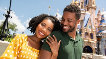 Una pareja sonriente disfruta un momento íntimo frente al Cinderella Castle en el Parque Temático Magic Kingdom