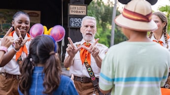 Trois membres de l’équipe expliquant aux clients comment faire des panneaux manuels inspirés des oiseaux au Disney’s Animal Kingdom theme park
