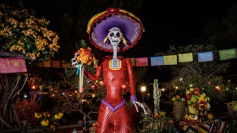 During Day of the Dead Celebrations at the Disneyland Resort is the iconic skeleton figurine La Catrina, the symbol of the Day of the Dead with flowers and a decorative hat