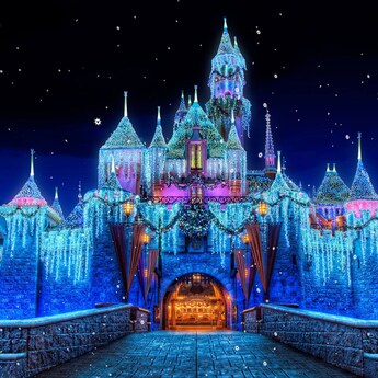 Sleeping Beauty Castle decorated with lights during a nighttime winter celebration
