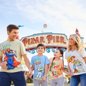 A mother, father and their 2 children sit near Spaceship Earth, wearing T-shirts with text that reads 'eat, sleep, Disney, repeat'