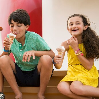A young boy and girl enjoying ice cream cones on a Disney cruise ship A young boy and girl enjoying ice cream cones on a Disney cruise ship