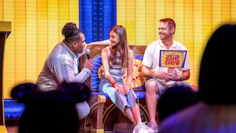 A girl, a man and a host on a game show at Saga lounge on board the Disney Destiny ship