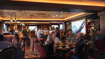 Guests socializing over beverages at Cask & Cannon aboard the Disney Destiny