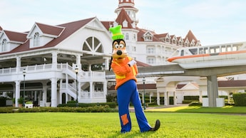 Goofy posing on a lawn outside Disney’s Grand Floridian Resort & Spa as the monorail approaches