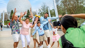 Six Guests posing for a photo in front of Spaceship Earth at Epcot