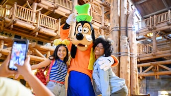 Goofy and 2 Guests posing for a photo at Disney’s Wilderness Lodge