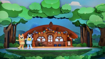Bingo y Bluey posan en un escenario que simula una casa en el bosque en ¡El Mejor Día de Bluey!