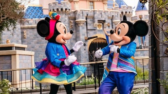 Mickey and Minnie dancing in front of the Sleeping Beauty Castle in the Disneyland 70th Anniversary costumes.