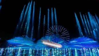 A water fountain with lights and a Ferris wheel at the World of Color One show at Disneyland Resort