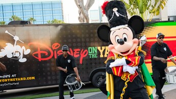 Mickey Mouse, dressed as a drum major, performs with a drumline in front of a Disney on the Yard bus at Disneyland Resort