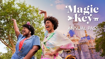 Two young ladies dancing happily in front of the Sleeping Beauty Castle at the Disneyland Park.