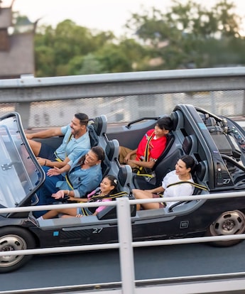A family of 5 Guests smiling as they ride Test Track at Epcot