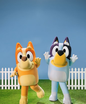 Bingo and Bluey standing together while waving