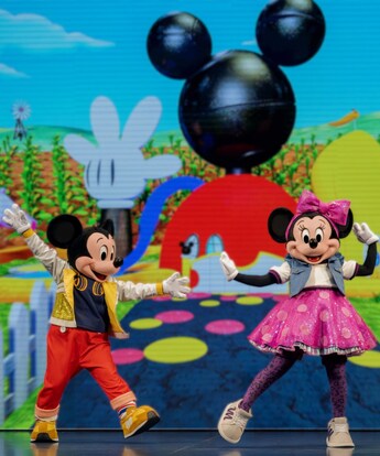 Mickey Mouse and Minnie Mouse dancing together on stage