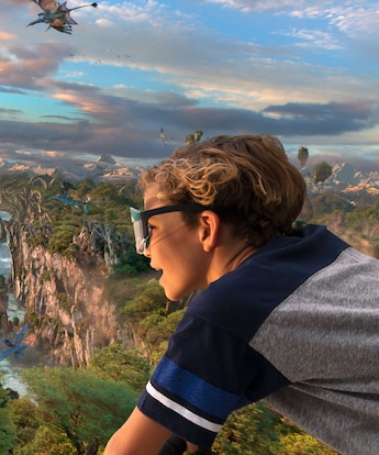 A young boy riding a banshee on the Avatar Flight of Passage attraction