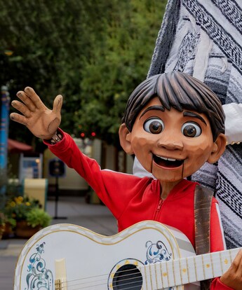 A life size puppet of Miguel from ‘Coco’ holding a guitar and waving