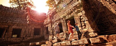 A family walks along a stone walkway at Angkor Archaeological Park