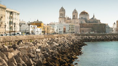 Concrete blocks fortify the shoreline next to old buildings in Cadiz Spain