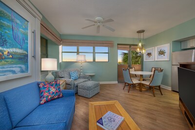A Disney’s Vero Beach Resort 2 bedroom villa with a sleeper sofa, sleeper chair, dining table, refrigerator and TV