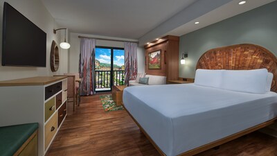 A Deluxe Studio Resort View room at Copper Creek Villas & Cabins at Disney's Wilderness Lodge with a bed, a cabinet, a dresser, a TV, a dining table, a low table, a sofa and a balcony with Resort views