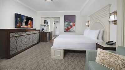 A Deluxe Studio furnished with a bed and entertainment center