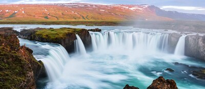 The spectacular Godafoss, one of the biggest waterfalls in Iceland, surrounded by scenic snow capped mountains