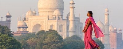 A woman wearing a sari walks in front of the Taj Mahal in Agra, India