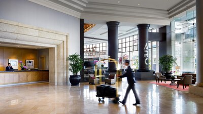 A bellboy pushing a luggage cart through the lobby of a luxury hotel