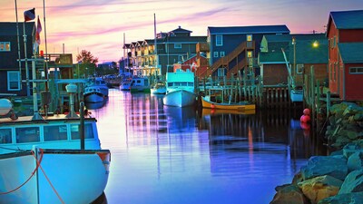 Fishing boats next to docks in a canal lined by houses