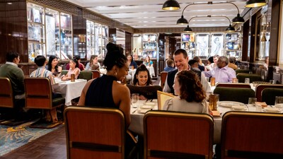 Guests dining in an elegant 1920s themed restaurant with linen table cloths and leather chairs