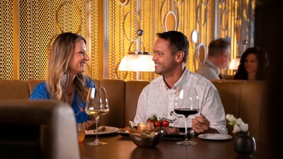 A couple drinking wine and eating dinner at Palo Steakhouse 