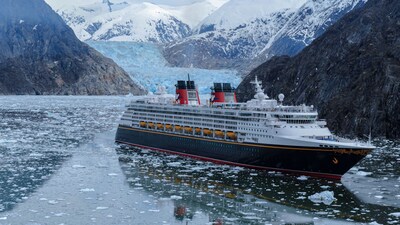 The Disney Wonder cruise ship sailing by snowcapped mountains