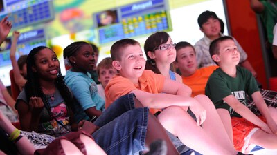 A large group of tweens watching something together at Edge, a youth club