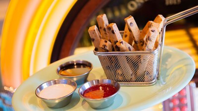 A basket of cookie fries served with a trio of dipping sauces