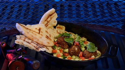 A bowl of hummus, meatballs and salsa served with pieces of pita bread