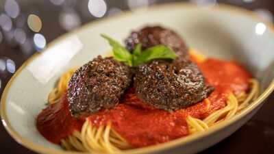 A bowl of spaghetti topped with 3 plant based meatballs