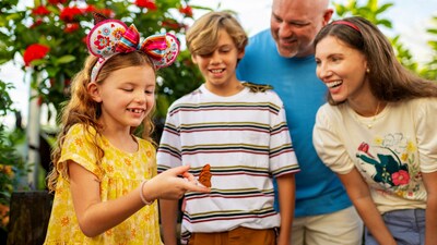 A family of 4 interacting with a butterfly at the Epcot International Flower and Garden Festival
