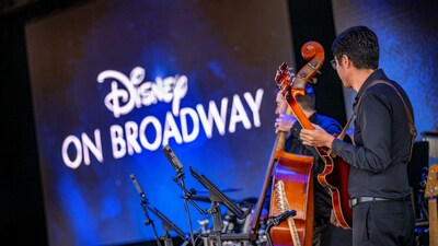 A group of people playing instruments onstage at the Disney On Broadway Concert Series