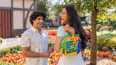 A man and a woman strolling along a path with vibrant flowers