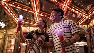 A couple holding up Mickey Mouse Light Up Bubble Wands at Main Street USA in Magic Kingdom park