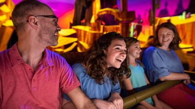 A father, mother and their 2 daughters riding Mickey & Minnie’s Runaway Railway